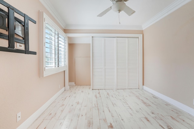 unfurnished bedroom featuring ornamental molding, a closet, baseboards, and wood finished floors