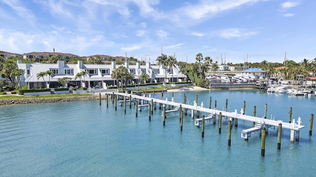 view of dock with a water view, boat lift, and a residential view