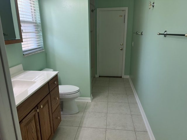 bathroom with tile patterned floors, toilet, vanity, and baseboards