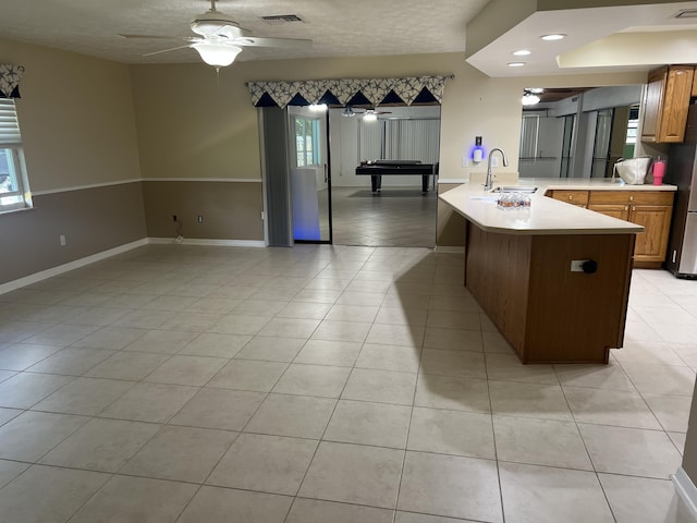 kitchen with visible vents, a ceiling fan, a sink, a peninsula, and light countertops