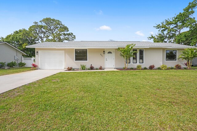 ranch-style home with a garage, a front lawn, concrete driveway, and stucco siding