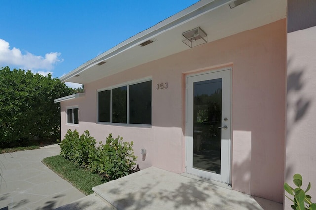 doorway to property with a patio area and stucco siding