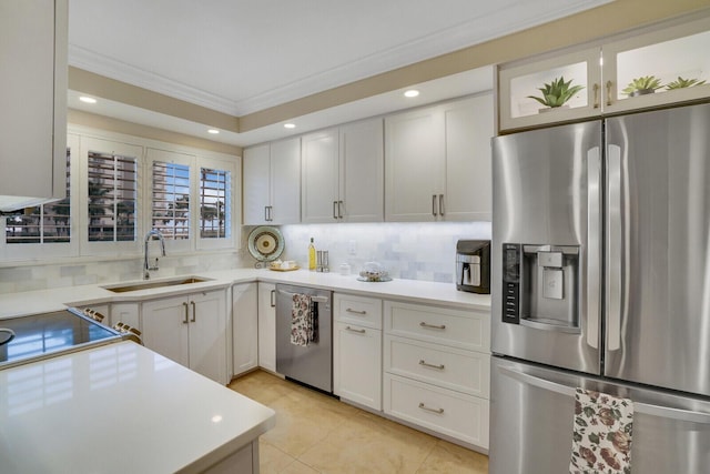 kitchen with light countertops, appliances with stainless steel finishes, a sink, and white cabinets