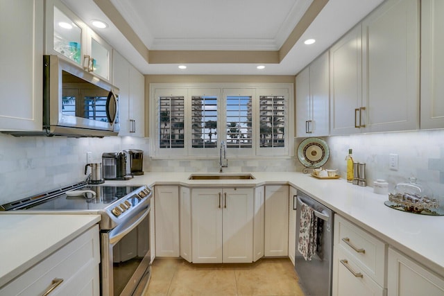 kitchen featuring light countertops, appliances with stainless steel finishes, a sink, and white cabinets