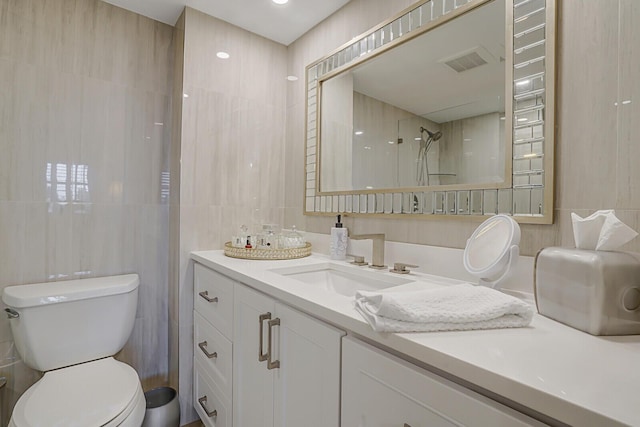 bathroom featuring toilet, visible vents, walk in shower, and tile walls