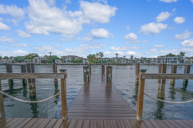 view of dock with a residential view and a water view