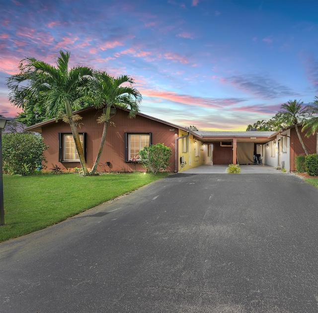 view of front of property featuring a carport, driveway, and a front lawn