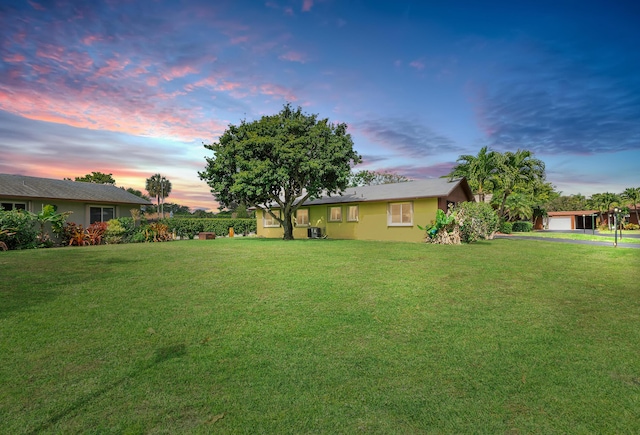 yard at dusk featuring a garage