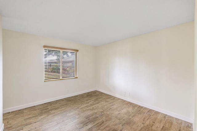 empty room with wood finished floors and baseboards