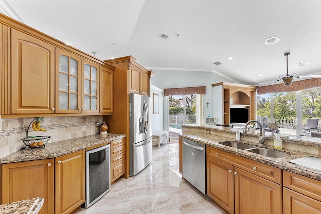 kitchen featuring beverage cooler, appliances with stainless steel finishes, dark stone counters, and a sink