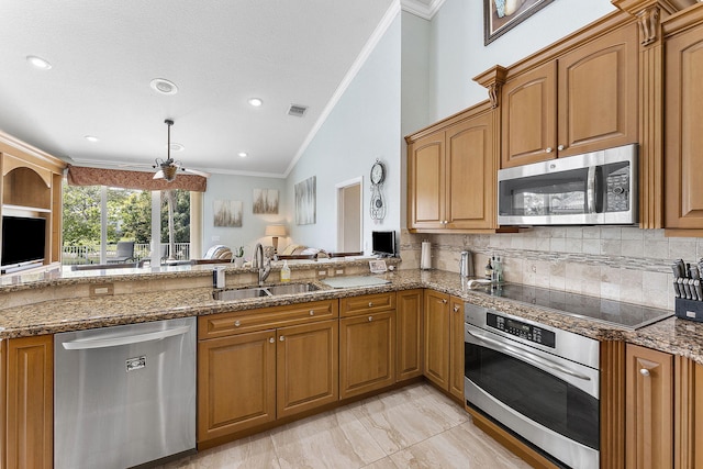 kitchen with dark stone counters, appliances with stainless steel finishes, and a sink