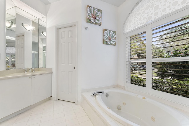 bathroom with tile patterned floors, a tub with jets, and vanity