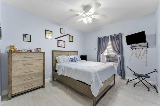 bedroom with baseboards, a ceiling fan, and light wood-style floors