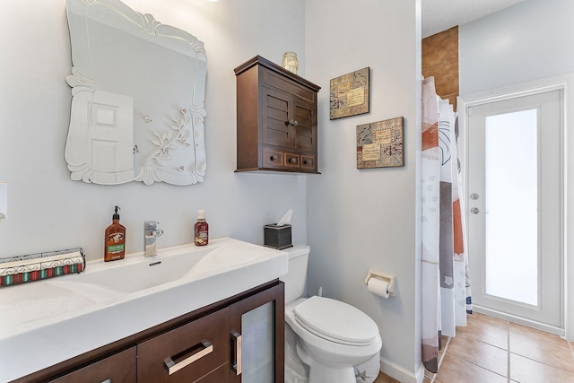 bathroom with tile patterned flooring, curtained shower, vanity, and toilet
