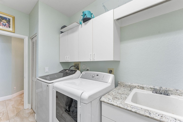 laundry room with cabinet space, a sink, washer and clothes dryer, and baseboards