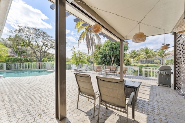 view of patio featuring a grill, fence, outdoor dining area, and a fenced in pool