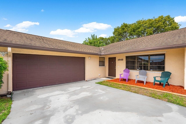 ranch-style house with concrete driveway, a shingled roof, an attached garage, and stucco siding