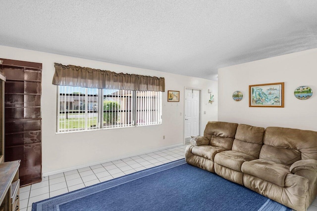 living room with tile patterned flooring, baseboards, and a textured ceiling