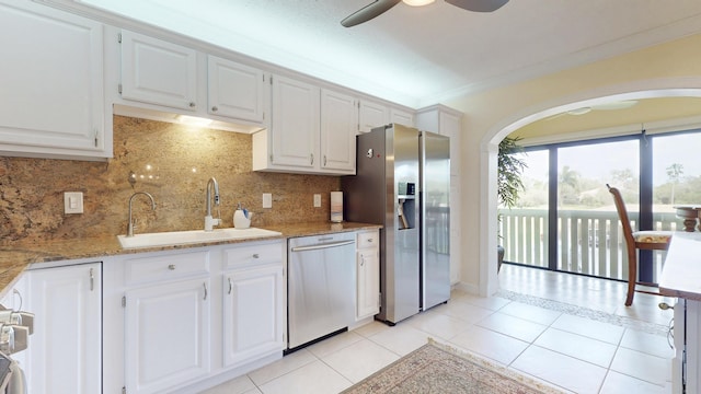 kitchen featuring light tile patterned floors, appliances with stainless steel finishes, white cabinets, and a sink