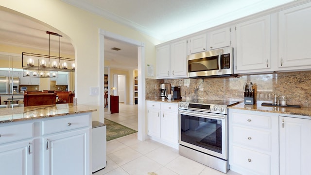 kitchen featuring white cabinetry, appliances with stainless steel finishes, backsplash, and crown molding