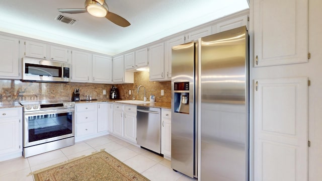 kitchen featuring light tile patterned floors, a sink, visible vents, appliances with stainless steel finishes, and backsplash