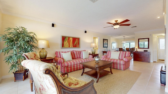 living room featuring a ceiling fan, visible vents, crown molding, and light tile patterned flooring