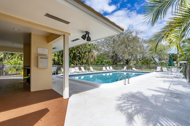 community pool featuring a patio area and fence