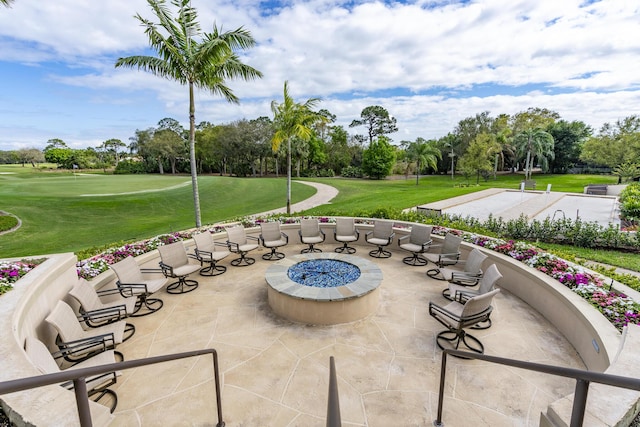 view of property's community featuring a fire pit, a patio, and a lawn