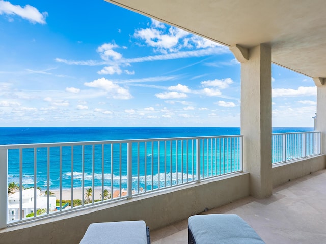 balcony featuring a view of the beach and a water view