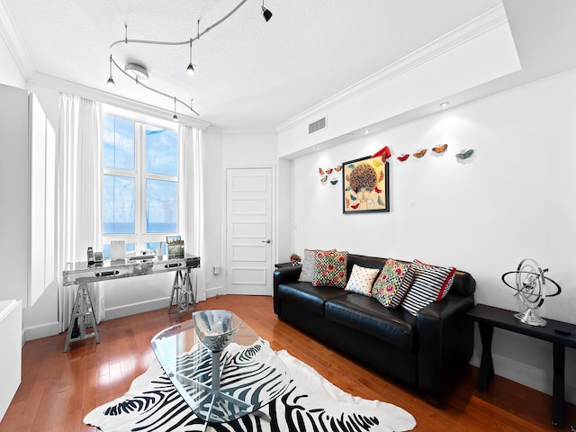 living area featuring crown molding, a textured ceiling, visible vents, and hardwood / wood-style floors