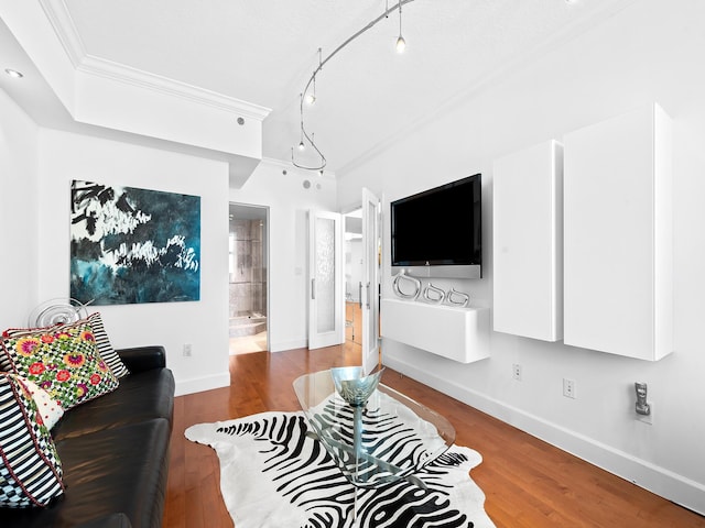 living room with rail lighting, baseboards, crown molding, and wood finished floors