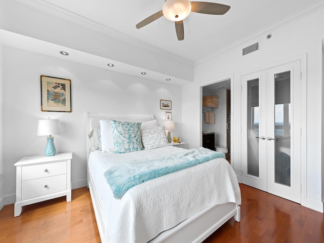 bedroom featuring visible vents, baseboards, french doors, ornamental molding, and light wood-type flooring