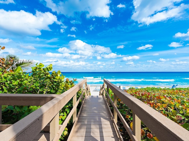 view of home's community with a water view and a beach view