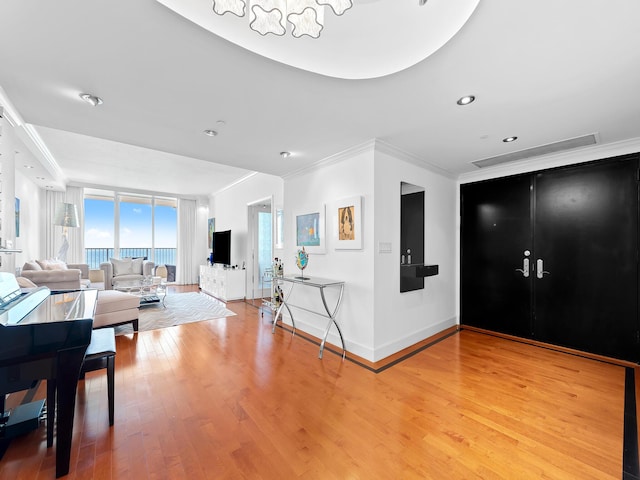 living room with french doors, crown molding, recessed lighting, wood finished floors, and baseboards