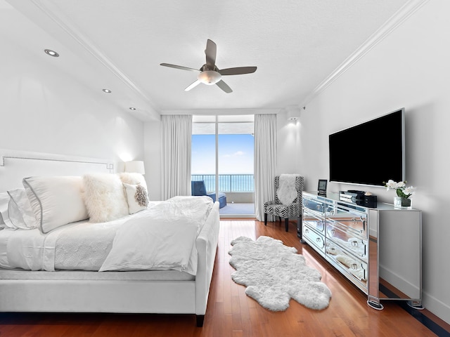 bedroom featuring wood finished floors, a ceiling fan, access to outside, expansive windows, and crown molding