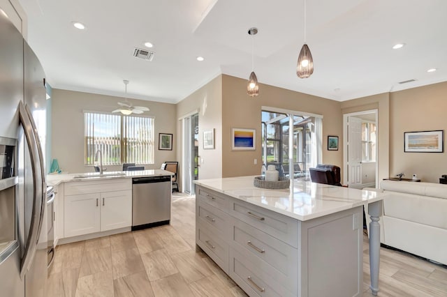 6782 Hillsdale Pt, Boynton Beach, FL 33437 - kitchen featuring appliances with stainless steel finishes, decorative light fixtures, light stone countertops, white cabinetry, and a sink