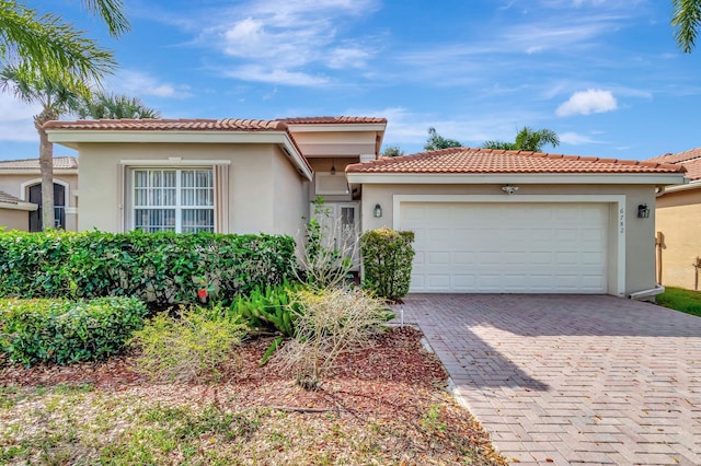 view of front of property featuring a garage, decorative driveway, and stucco siding