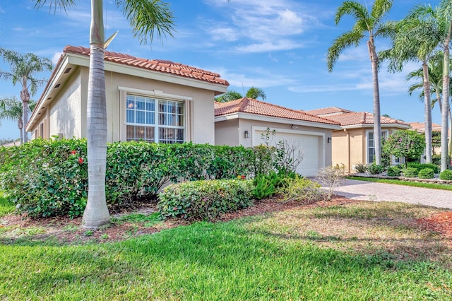 mediterranean / spanish house featuring a tile roof, driveway, an attached garage, and stucco siding