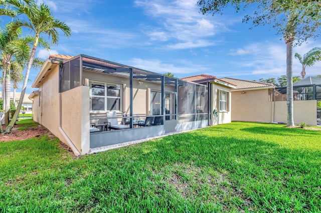 6782 Hillsdale Pt, Boynton Beach, FL 33437 - rear view of house with glass enclosure, a lawn, and stucco siding