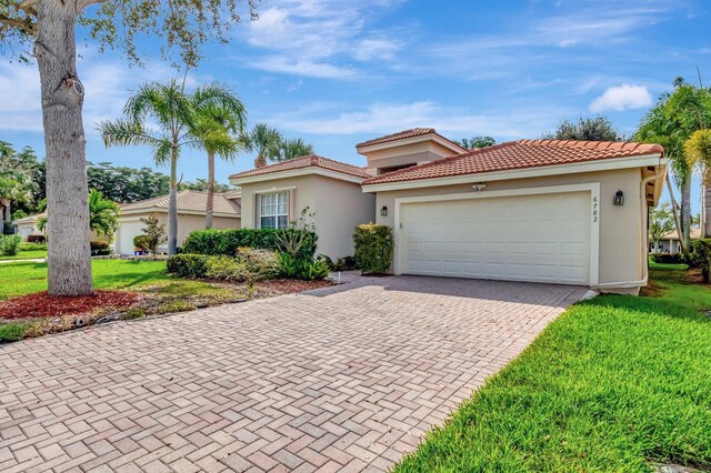 6782 Hillsdale Pt, Boynton Beach, FL 33437 - mediterranean / spanish home featuring decorative driveway, stucco siding, an attached garage, a tiled roof, and a front lawn