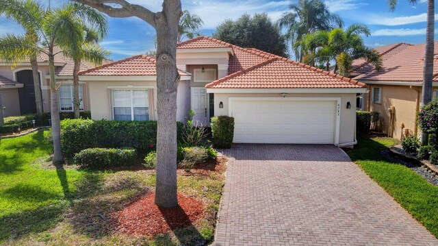 6782 Hillsdale Pt, Boynton Beach, FL 33437 - mediterranean / spanish house featuring a garage, decorative driveway, and stucco siding
