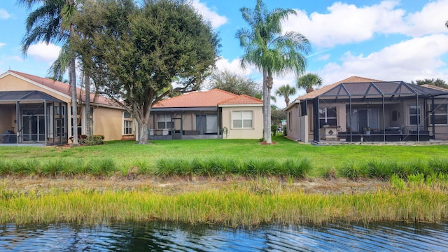 6782 Hillsdale Pt, Boynton Beach, FL 33437 - rear view of property featuring a lanai, a water view, a tile roof, a lawn, and stucco siding