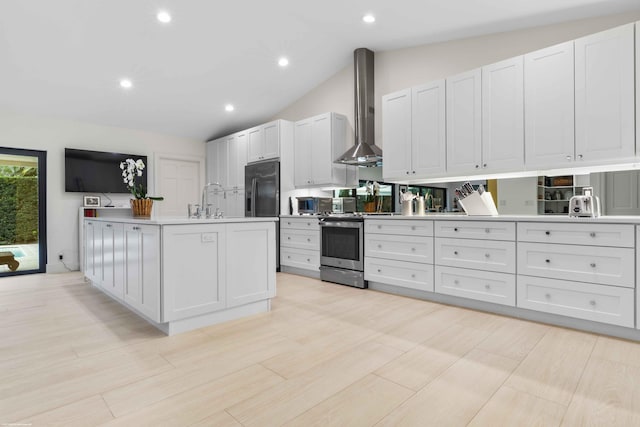 kitchen with lofted ceiling, light countertops, a sink, stainless steel range with electric stovetop, and wall chimney exhaust hood