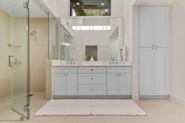 bathroom featuring double vanity, a shower stall, visible vents, and a sink