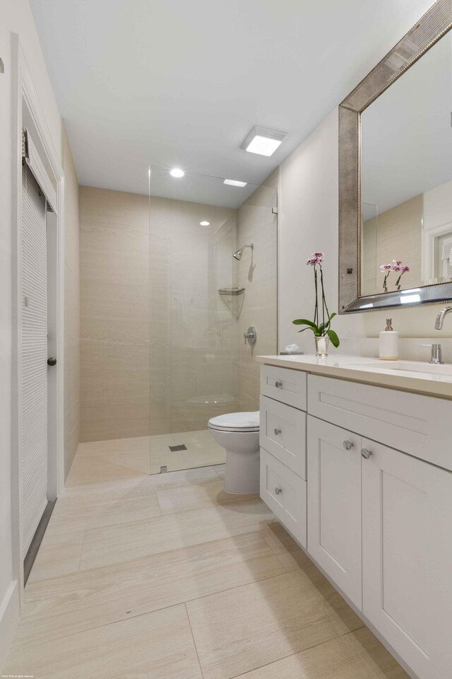 bathroom featuring vanity, toilet, and a walk in shower