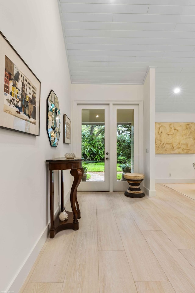 doorway featuring lofted ceiling and baseboards