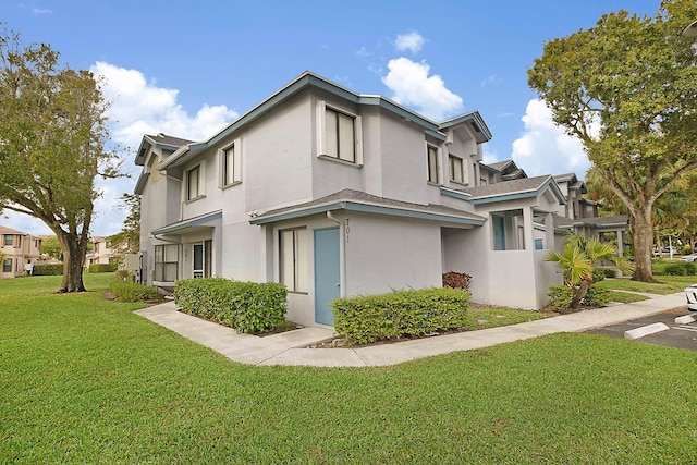 view of side of home with a lawn and stucco siding