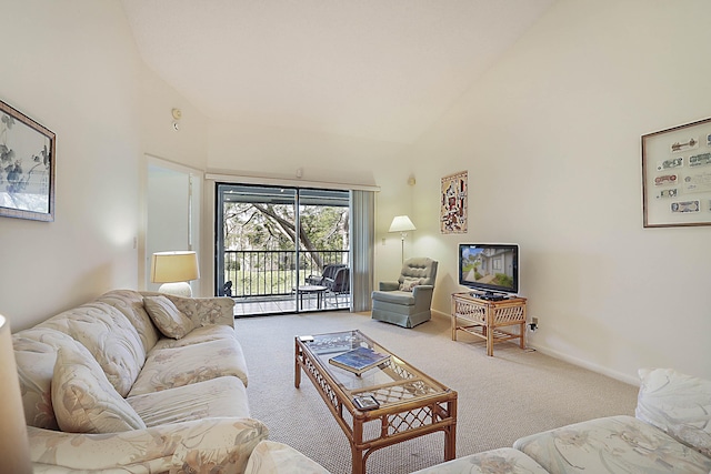 carpeted living room featuring baseboards and high vaulted ceiling