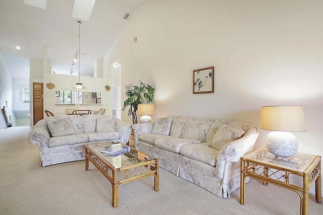 carpeted living room with high vaulted ceiling and visible vents