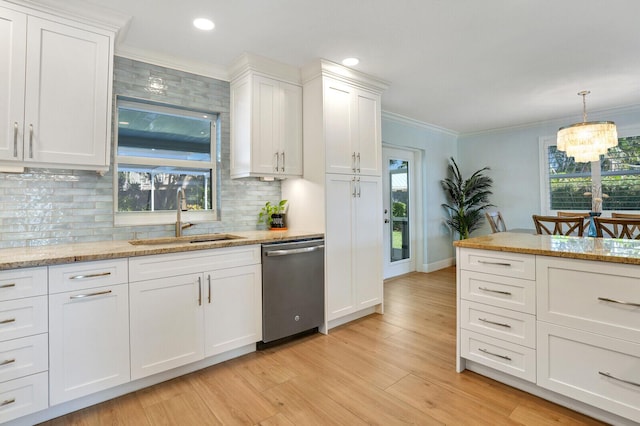 kitchen featuring ornamental molding, stainless steel dishwasher, a sink, and white cabinetry